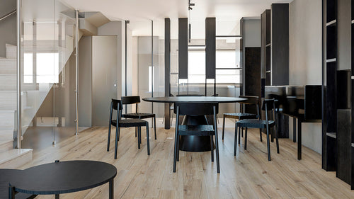 Vista general de comedor minimalista en proyecto de vivienda en El Masnou, con mobiliario negro y diseño arquitectónico moderno.